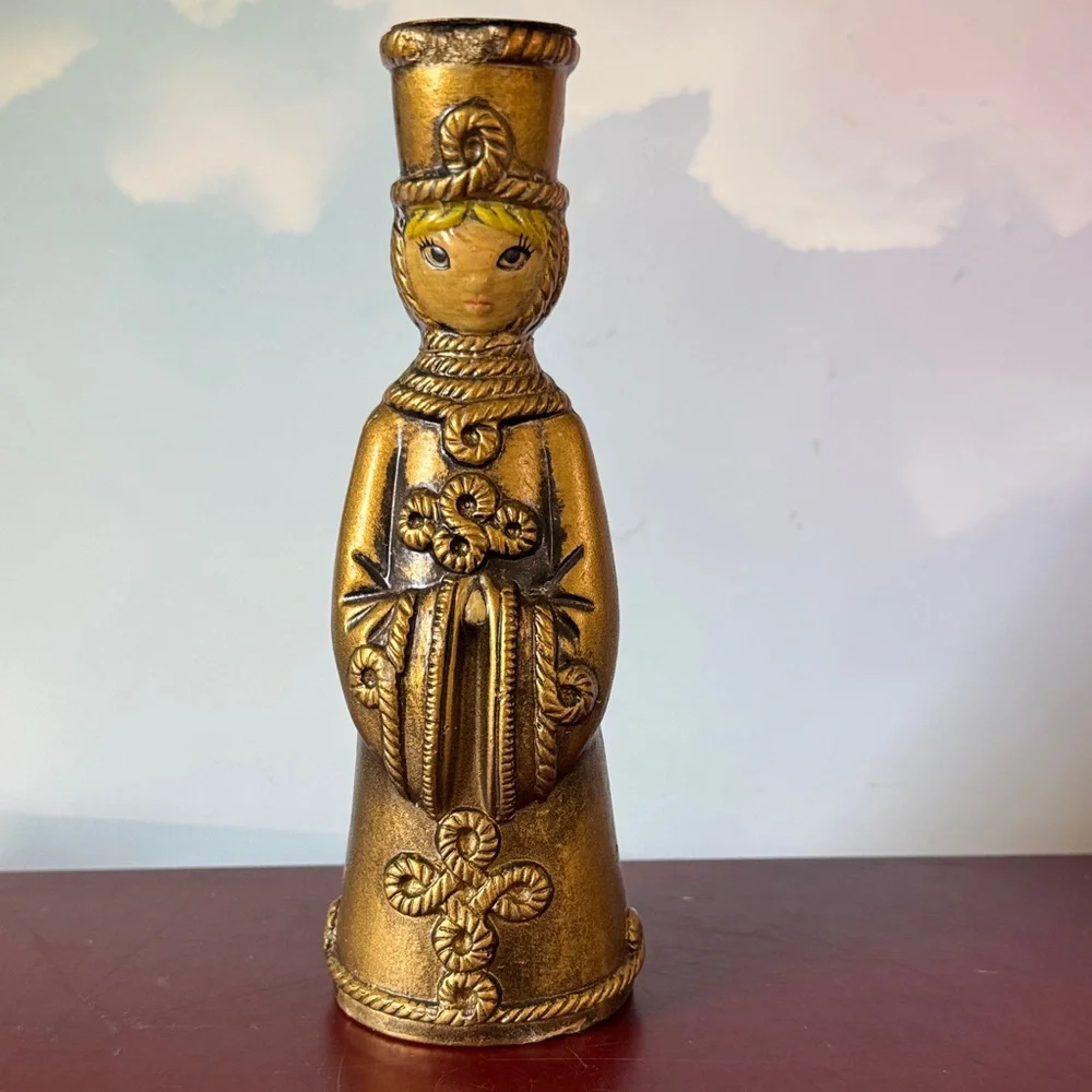 vintage chalkware candle holder featuring a metallic gold-finished figure